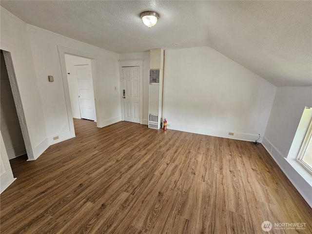 1651 S 35th St, Tacoma, WA 98418 - bonus room with a heating unit, a textured ceiling, wood finished floors, lofted ceiling, and baseboards