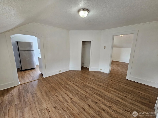 1651 S 35th St, Tacoma, WA 98418 - unfurnished room with a textured ceiling, wood finished floors, baseboards, ornamental molding, and vaulted ceiling