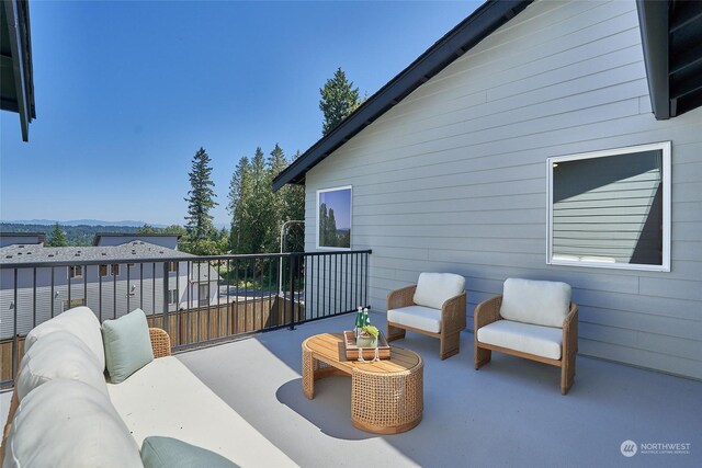 exterior space featuring a mountain view, a balcony, and an outdoor hangout area