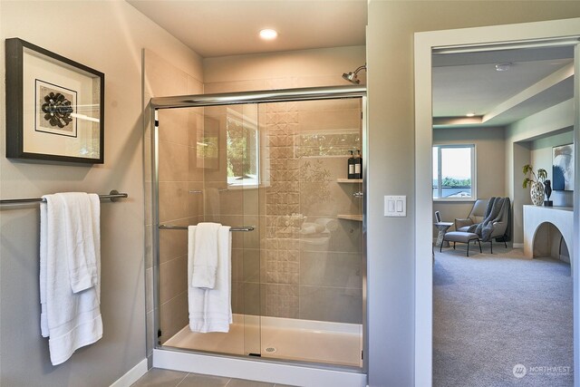 full bath featuring a stall shower and baseboards