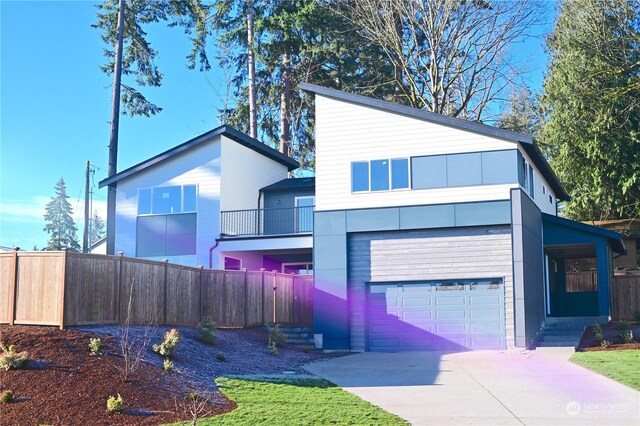 view of front of property featuring a garage, driveway, and fence