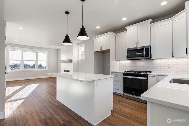 kitchen with white cabinetry, decorative light fixtures, a center island, electric range oven, and dark hardwood / wood-style flooring