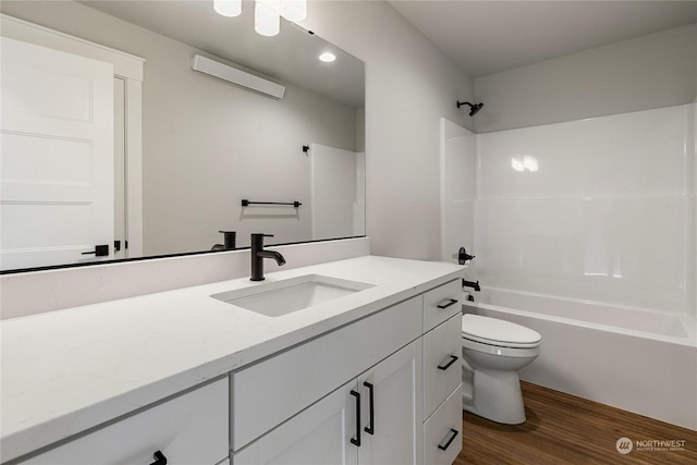 full bathroom with washtub / shower combination, wood-type flooring, toilet, and vanity