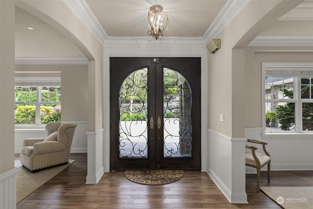 foyer entrance featuring plenty of natural light, dark hardwood / wood-style floors, crown molding, and french doors