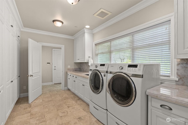 laundry room featuring independent washer and dryer, crown molding, and cabinets