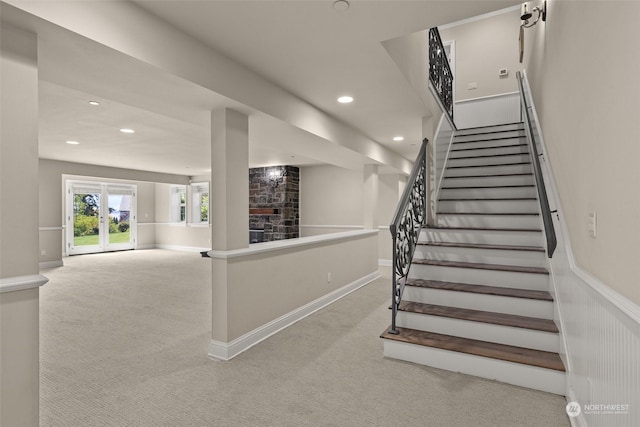 staircase with carpet flooring and a fireplace