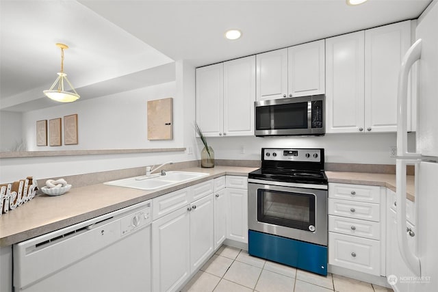 kitchen featuring decorative light fixtures, sink, white cabinetry, appliances with stainless steel finishes, and light tile patterned floors