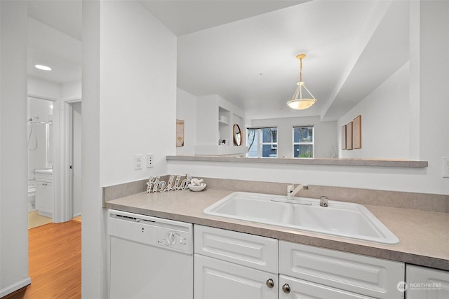 kitchen with hardwood / wood-style floors, dishwasher, pendant lighting, white cabinets, and sink