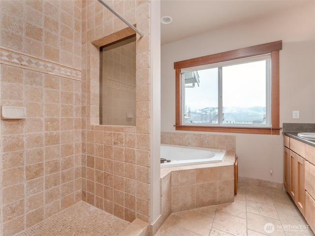 full bath with stone tile floors, a bath, vanity, and a tile shower