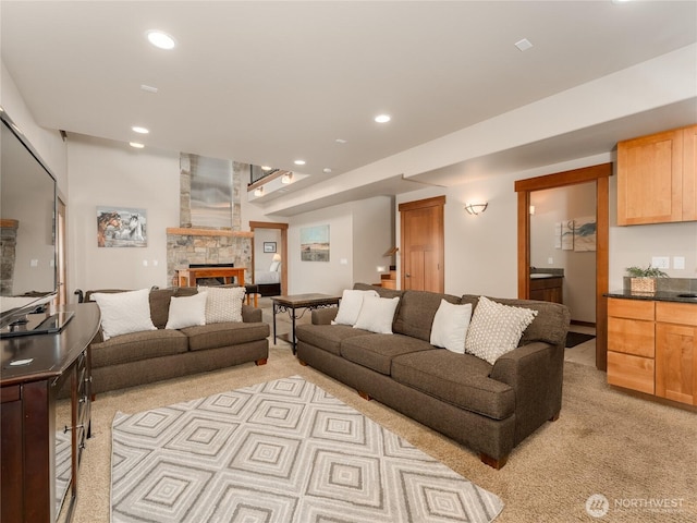 living room featuring a stone fireplace, stairs, recessed lighting, and light carpet