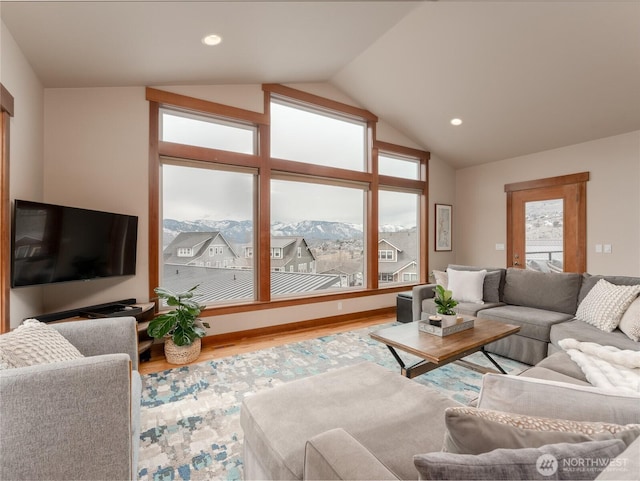 living area featuring recessed lighting, a mountain view, lofted ceiling, and wood finished floors