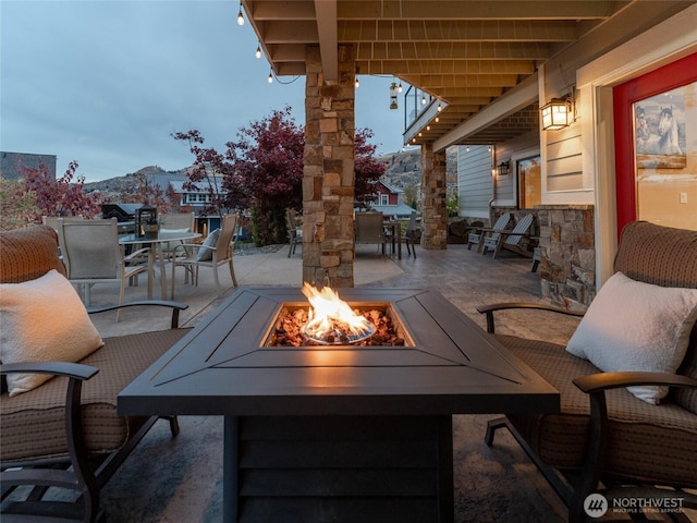 view of patio / terrace featuring a mountain view, a fire pit, and outdoor dining area