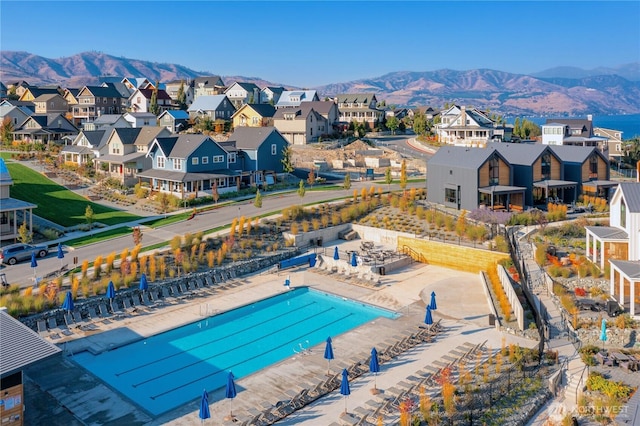 community pool with a mountain view, a residential view, and fence