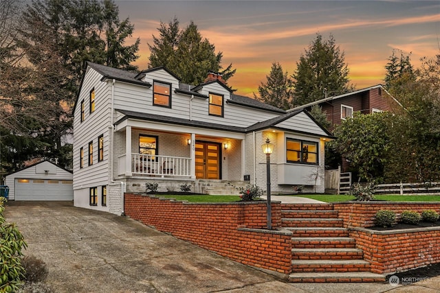 view of front of property featuring covered porch, a garage, and an outdoor structure