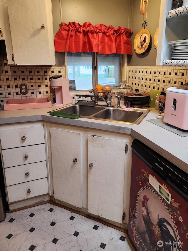 kitchen featuring sink, dishwashing machine, and decorative backsplash