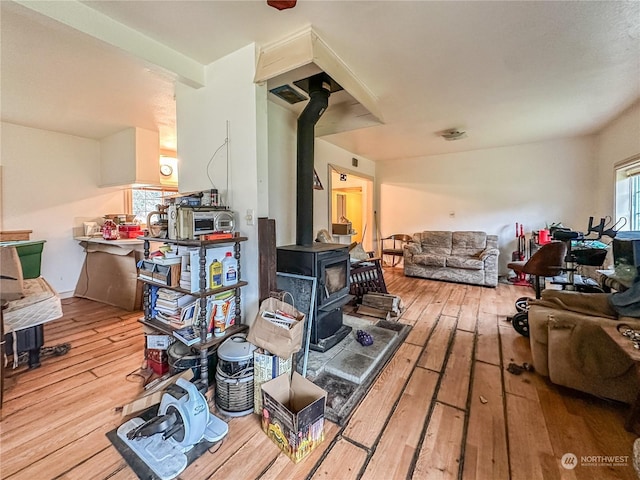 interior space with light hardwood / wood-style floors and a wood stove