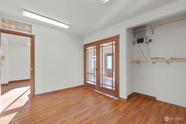 unfurnished room with french doors and light hardwood / wood-style flooring