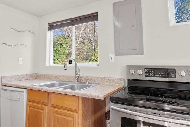 kitchen with light brown cabinets, sink, stainless steel range with electric stovetop, white dishwasher, and electric panel