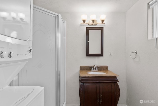 bathroom with stacked washing maching and dryer and vanity