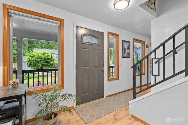 foyer entrance featuring a textured ceiling and hardwood / wood-style floors