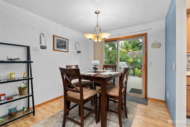 dining space with light wood-type flooring and a chandelier