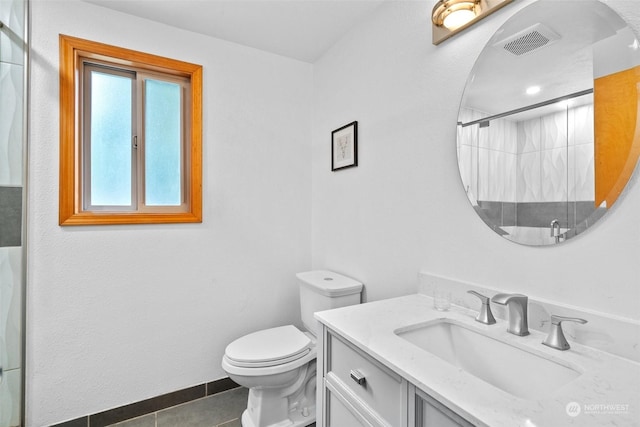 bathroom with toilet, vanity, tile patterned flooring, and a shower with door