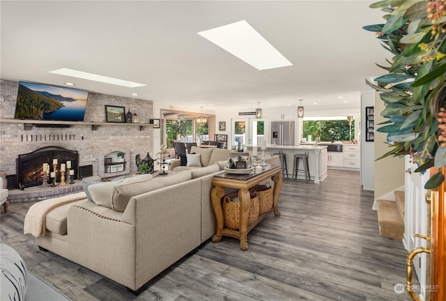 living room with a healthy amount of sunlight, a skylight, and a fireplace