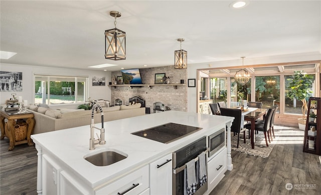 kitchen featuring white cabinetry, sink, hanging light fixtures, and stainless steel appliances