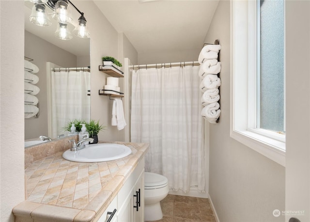 bathroom with toilet, vanity, and tile patterned floors