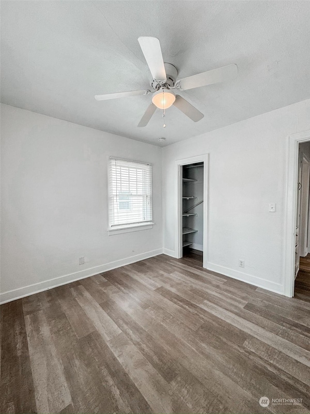 unfurnished bedroom with ceiling fan, dark hardwood / wood-style flooring, and a closet