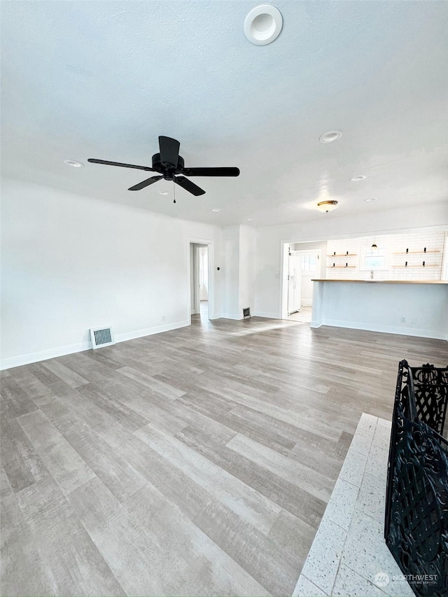 unfurnished living room with ceiling fan and light hardwood / wood-style flooring