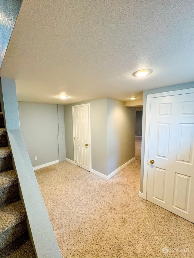 basement featuring carpet flooring and a textured ceiling