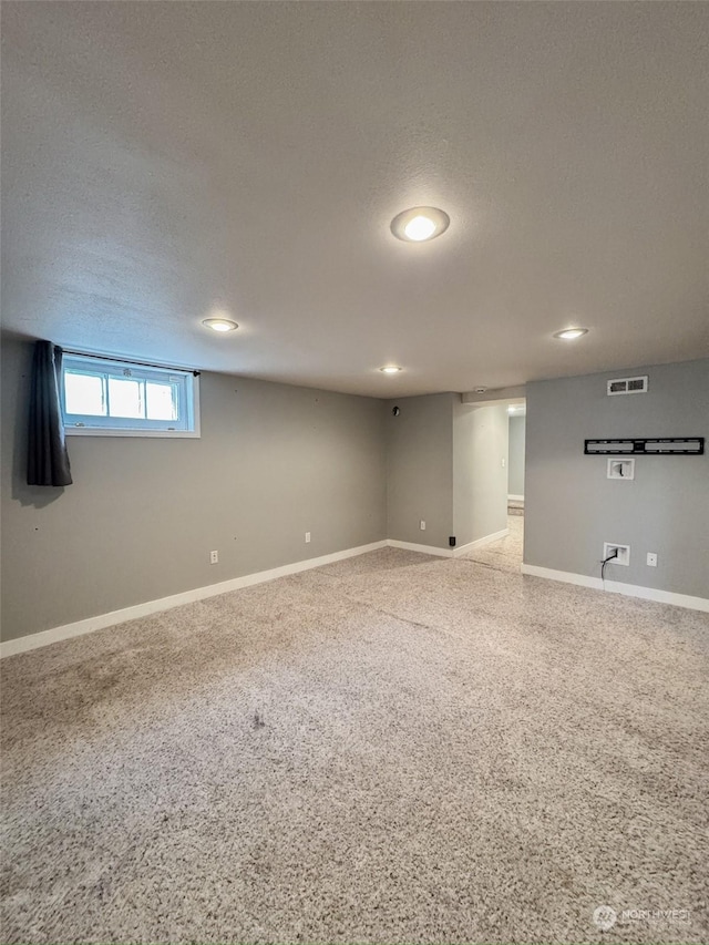 basement featuring a textured ceiling and carpet