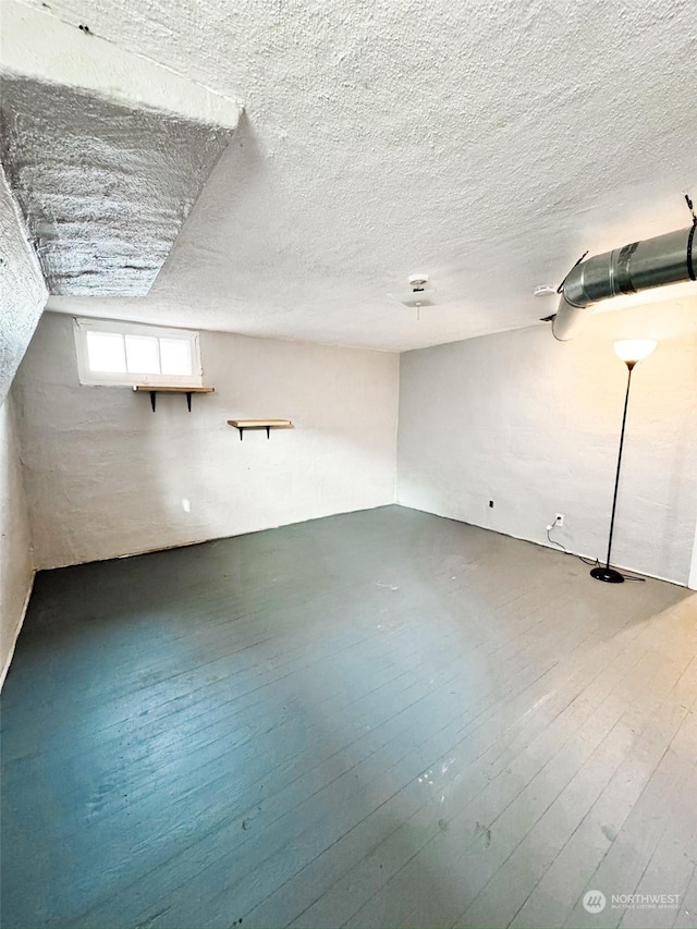 bonus room with hardwood / wood-style floors and a textured ceiling