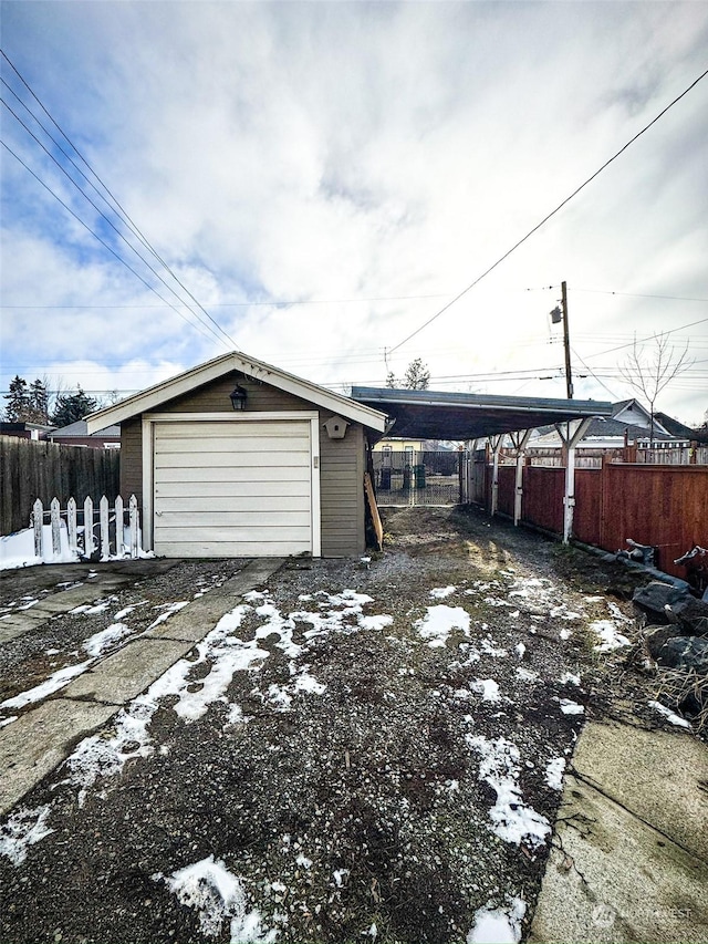 snow covered garage featuring a carport