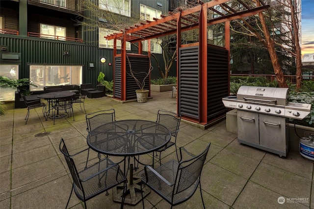 patio terrace at dusk featuring a pergola and grilling area