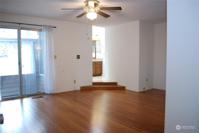 spare room featuring ceiling fan, hardwood / wood-style floors, and a textured ceiling