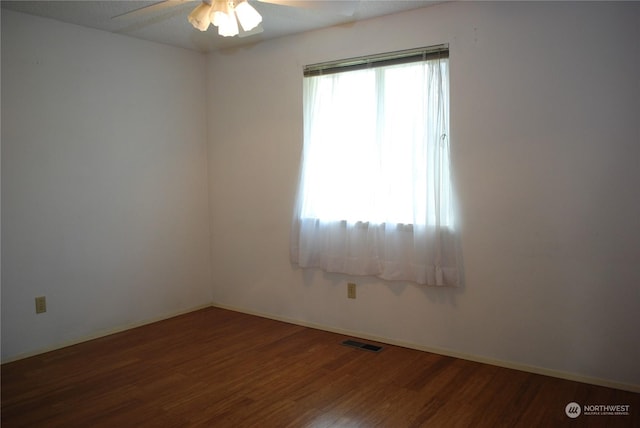 empty room with dark wood-type flooring and ceiling fan