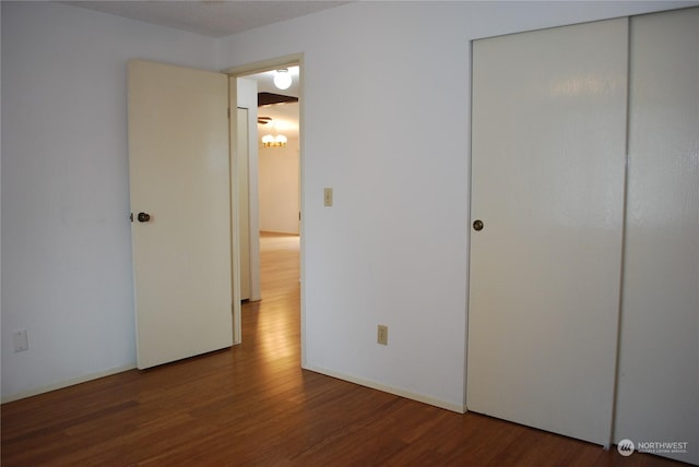 unfurnished bedroom featuring hardwood / wood-style floors and a closet