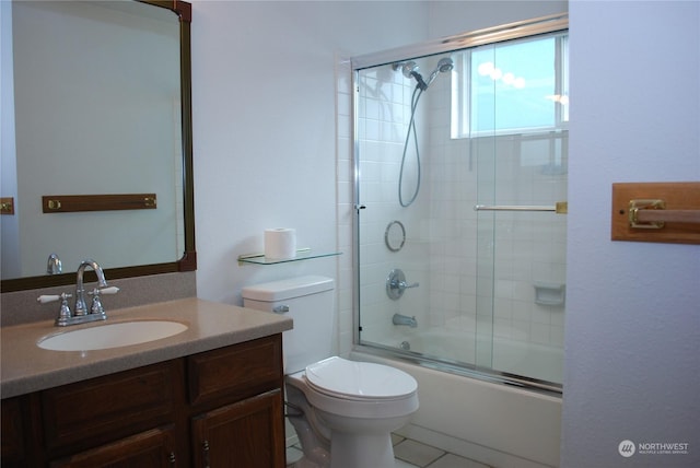 full bathroom with vanity, bath / shower combo with glass door, and toilet