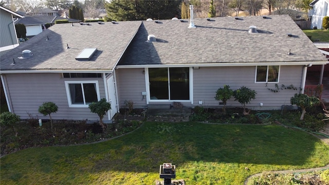 rear view of house featuring a yard