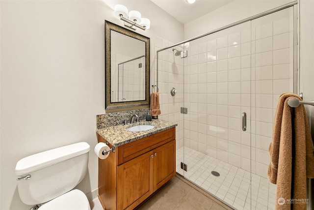 bathroom featuring toilet, walk in shower, tile patterned floors, and vanity