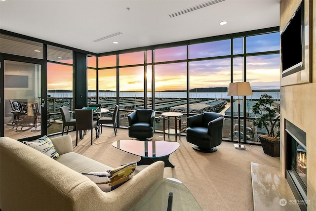 carpeted living room featuring a wall of windows and a high end fireplace