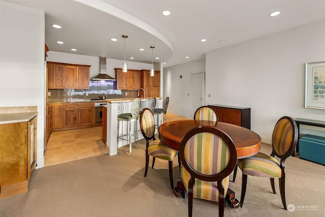 dining room featuring sink and light colored carpet