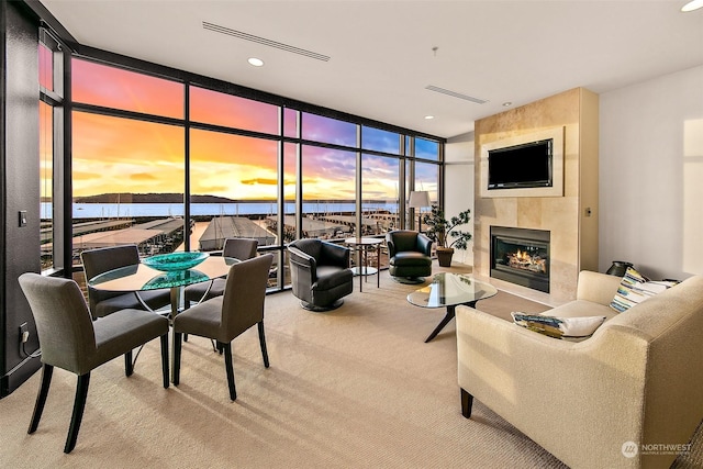 living room with a water view, a wall of windows, and carpet floors