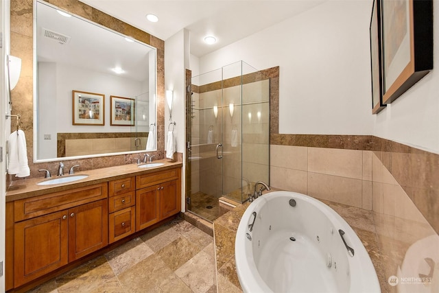 bathroom featuring tile walls, vanity, and plus walk in shower