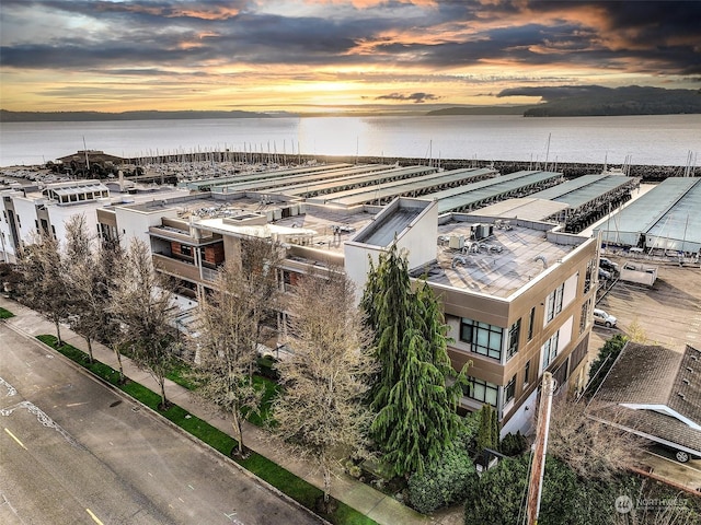 aerial view at dusk featuring a water view