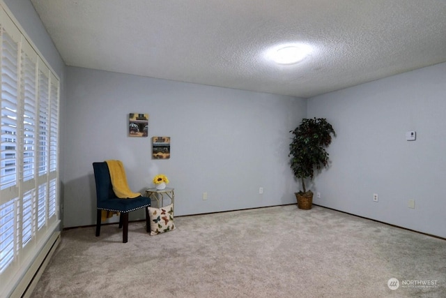 unfurnished room featuring a textured ceiling, baseboard heating, and light colored carpet