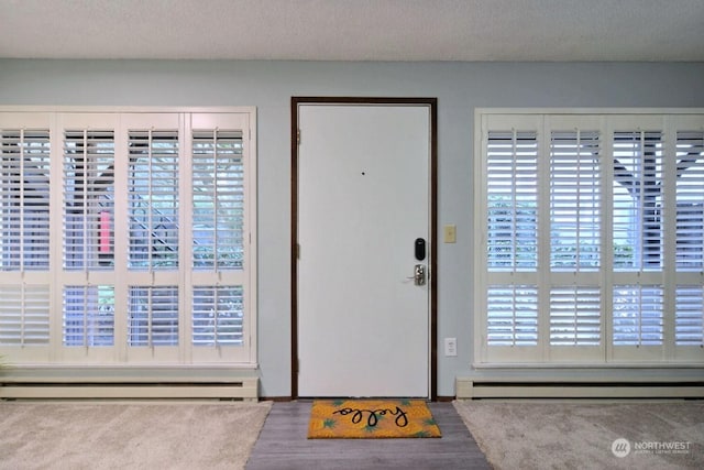 entrance foyer featuring a baseboard radiator and a textured ceiling