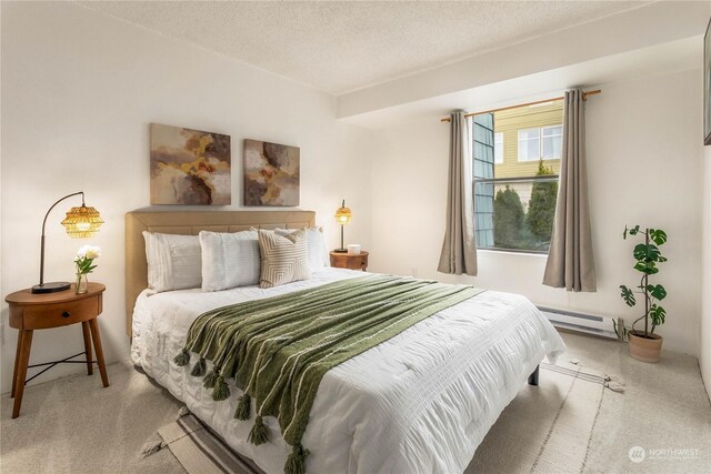 carpeted bedroom with baseboard heating and a textured ceiling